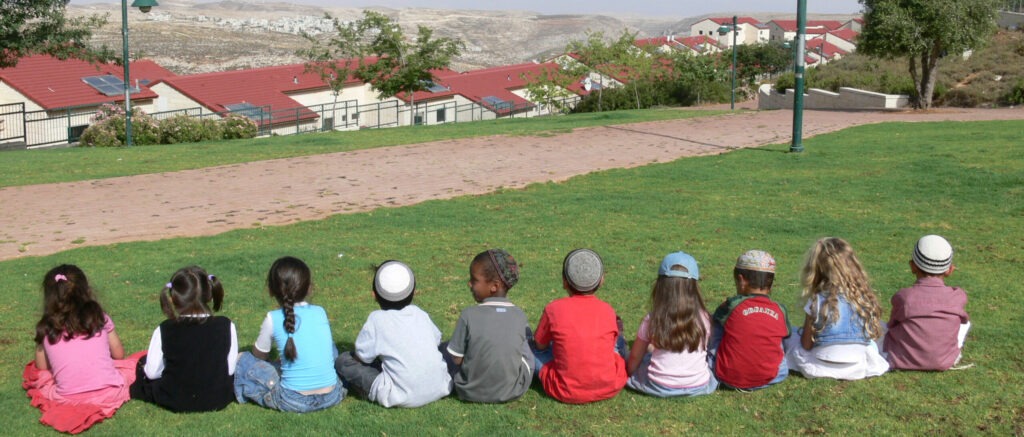 תמונה של ילדים יושבים על דשא בשורה